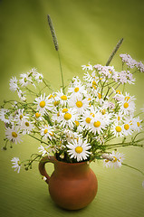 Image showing Bouquet of wild flowers in a clay pot, close-up  