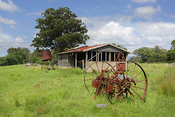 Image showing Old derelict farm shed and rusty cart wheels at Benandarah