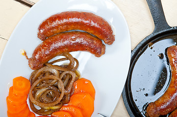 Image showing beef sausages cooked on iron skillet 