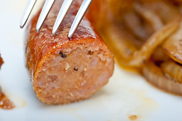 Image showing beef sausages cooked on iron skillet 