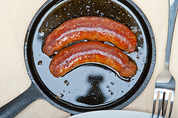 Image showing beef sausages cooked on iron skillet 