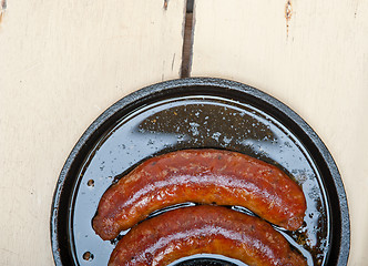 Image showing beef sausages cooked on iron skillet 