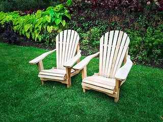 Image showing Wooden chairs on green lawn