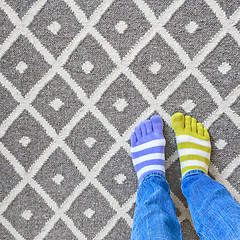 Image showing Legs in mismatched socks on gray carpet