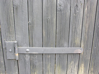 Image showing The iron door hinge of a wooden shelter