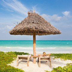 Image showing Woman sunbathing on tropical beach.