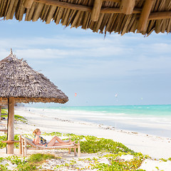 Image showing Woman sunbathing on tropical beach.