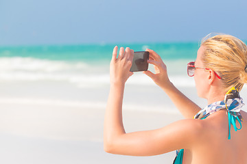 Image showing Woman taking photo on the beach.