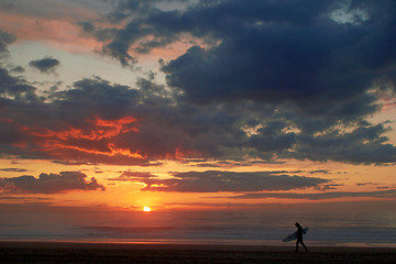 Image showing Surfer on the ocean beach at sunset or sunrise