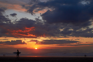 Image showing Surfer on the ocean beach at sunset or sunrise