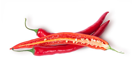 Image showing Two whole and one half red chili peppers