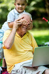 Image showing grandfather and child using laptop