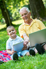 Image showing grandfather and child in park using tablet