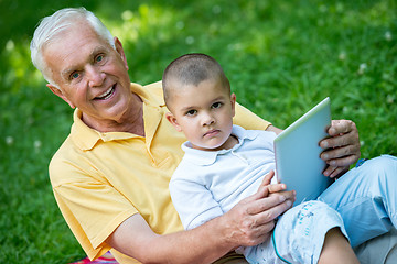 Image showing grandfather and child in park using tablet