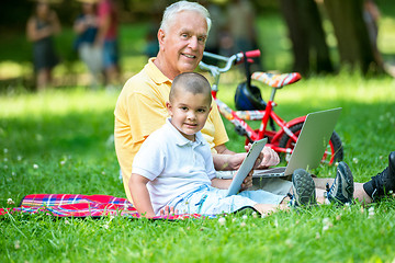 Image showing grandfather and child in park using tablet