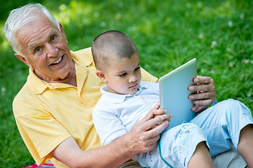 Image showing grandfather and child in park using tablet