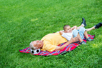 Image showing grandfather and child in park using tablet