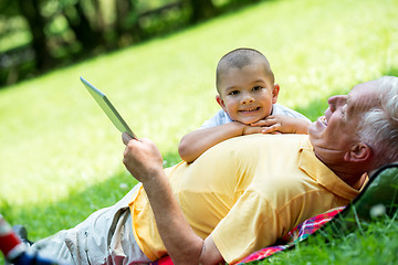 Image showing grandfather and child in park using tablet