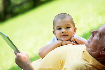 Image showing grandfather and child in park using tablet