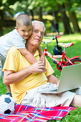 Image showing grandfather and child using laptop