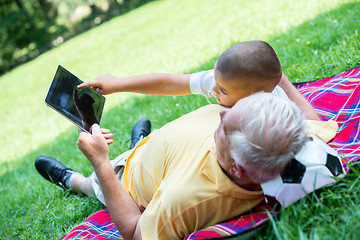 Image showing grandfather and child in park using tablet