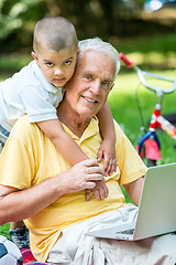 Image showing grandfather and child using laptop