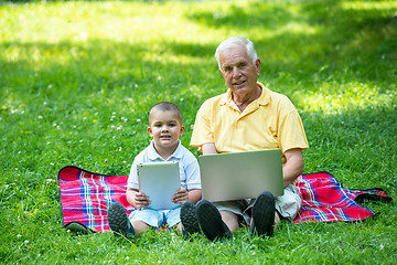 Image showing grandfather and child in park using tablet