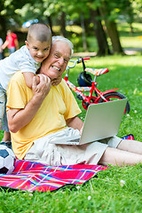 Image showing grandfather and child using laptop