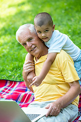 Image showing grandfather and child using laptop