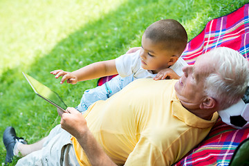 Image showing grandfather and child in park using tablet