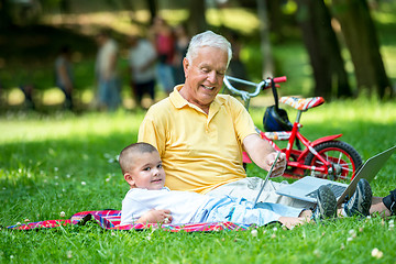 Image showing grandfather and child using laptop