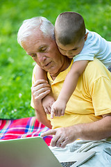 Image showing grandfather and child using laptop