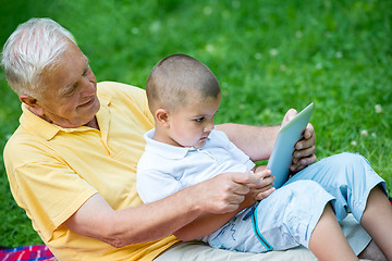 Image showing grandfather and child in park using tablet