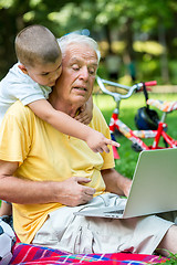 Image showing grandfather and child using laptop