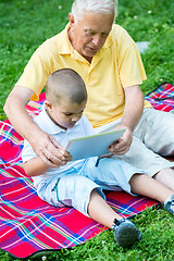 Image showing grandfather and child in park using tablet
