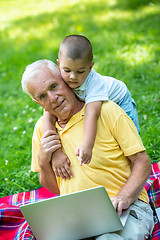 Image showing grandfather and child using laptop