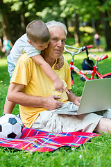 Image showing grandfather and child using laptop