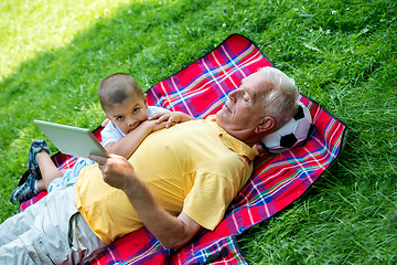 Image showing grandfather and child in park using tablet