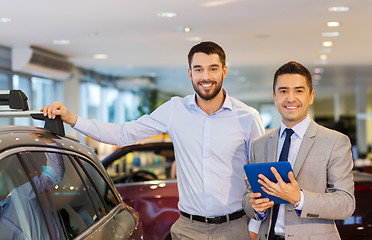 Image showing happy man with car dealer in auto show or salon