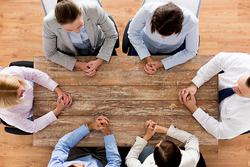 Image showing close up of business team sitting at table