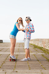 Image showing smiling couple with skateboard outdoors