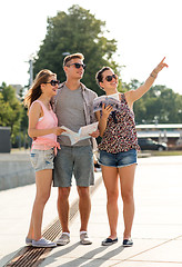 Image showing smiling friends with map and city guide outdoors