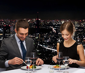 Image showing smiling couple eating main course at restaurant