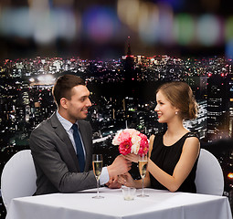 Image showing smiling man giving flower bouquet to woman