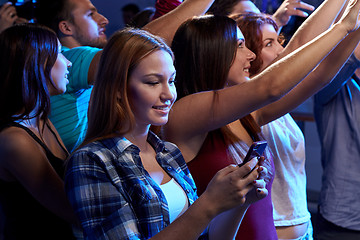 Image showing woman with smartphone texting message at concert