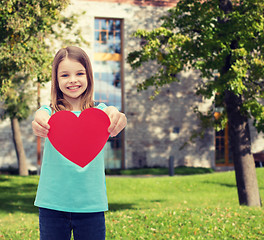 Image showing smiling little girl giving red heart