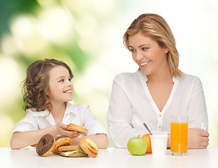 Image showing happy mother and daughter eating breakfast