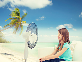 Image showing smiling little girl with big fan at home