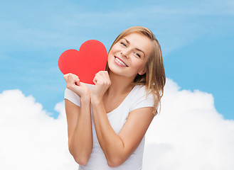 Image showing smiling woman in white t-shirt holding red heart