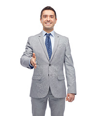 Image showing happy smiling businessman in suit shaking hand